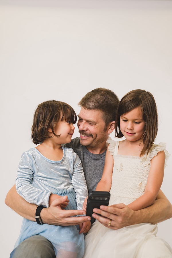 father and daughters reading a Wanderly story